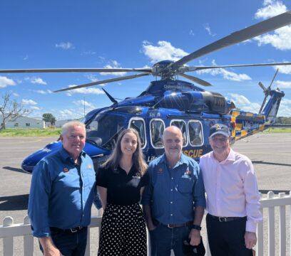 People standing in front of a helicopter