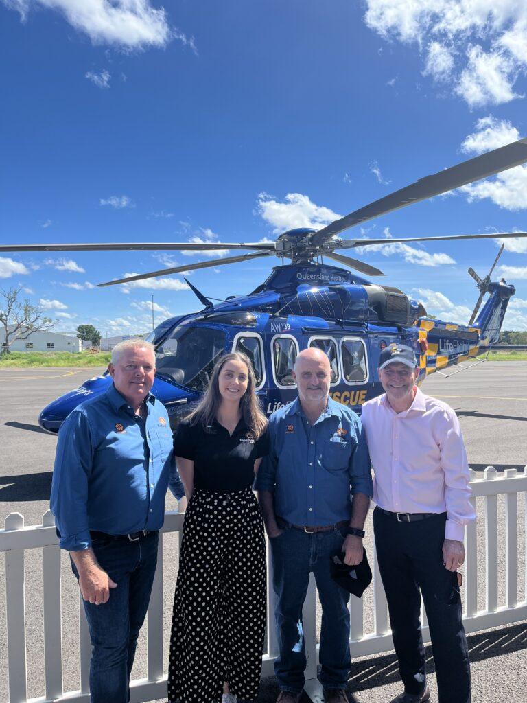 People standing in front of a helicopter